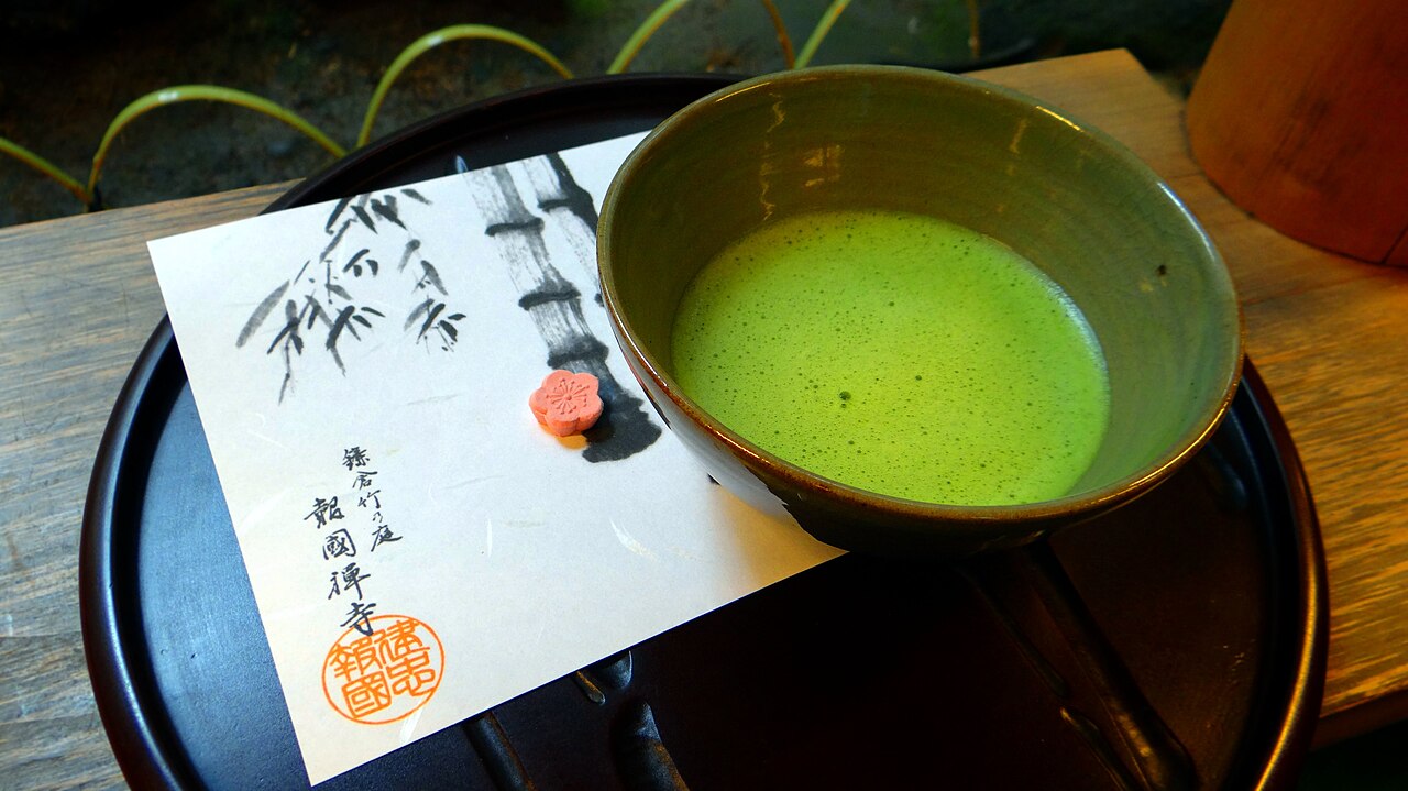 Tasse de matcha fraîchement fouetté, servie avec une sucrerie japonaise