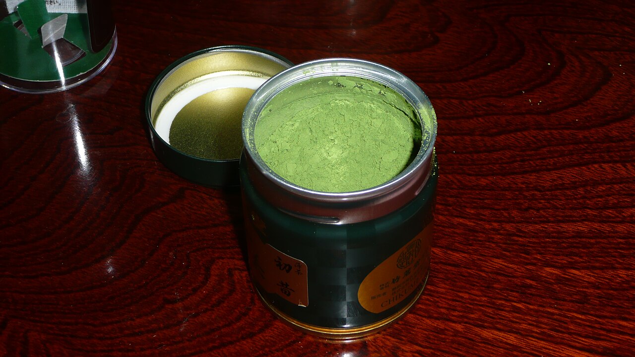 Boîte métallique ouverte de poudre de matcha vert pour la conservation